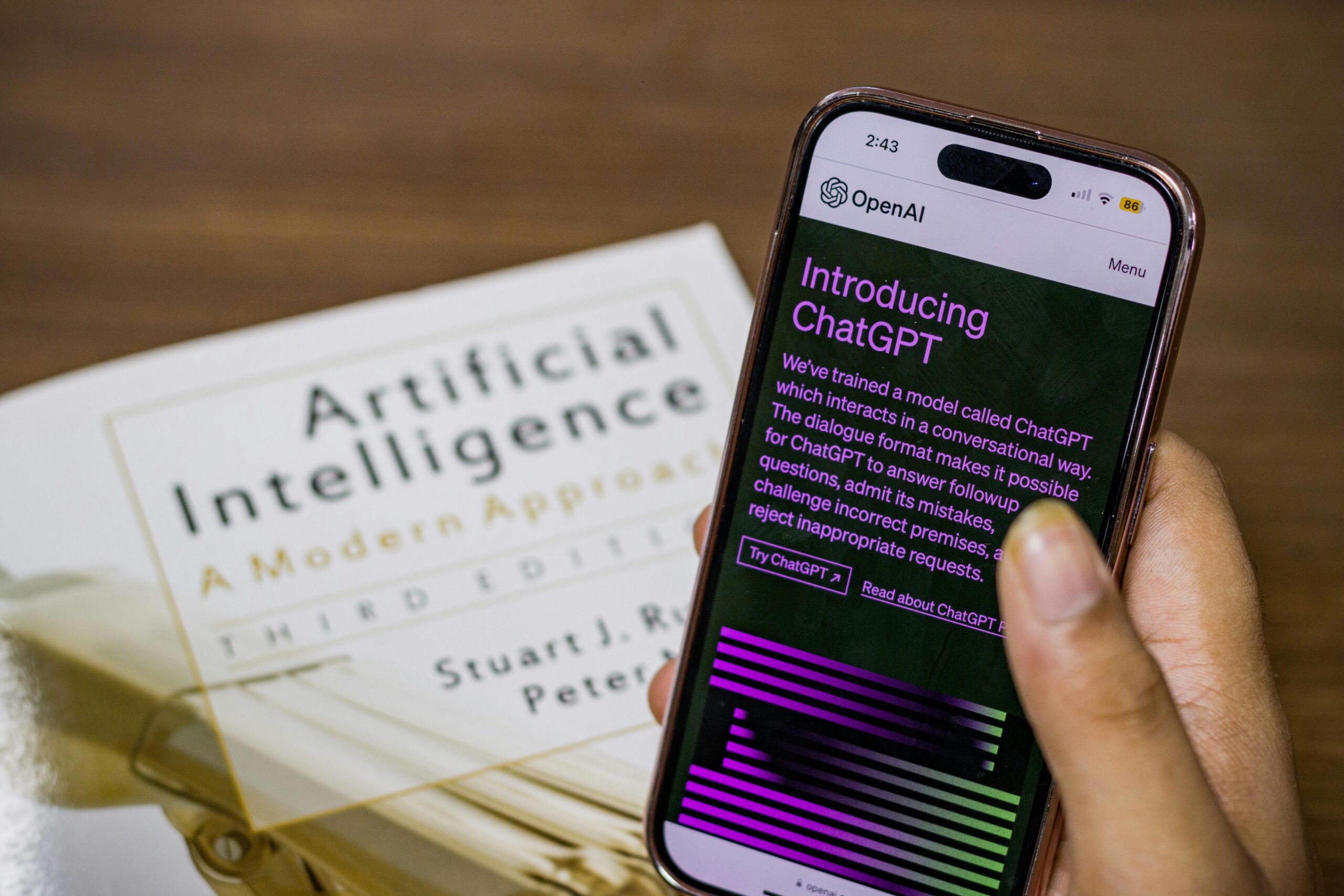 AI book and person using Chat GPT on their phone